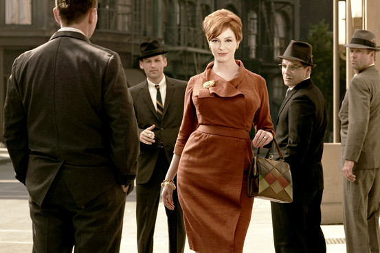Old timey photo with men in top hats and a woman in a dark orange coat