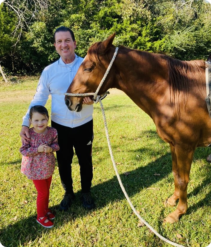 Dr. Newall standing with a horse and child