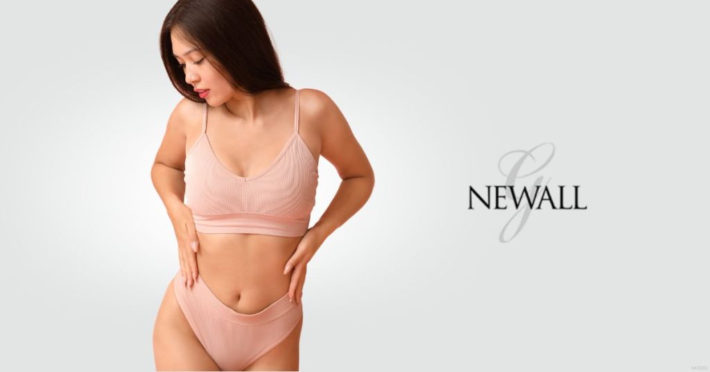 Woman in pink lingerie with her hands on her waist (model)